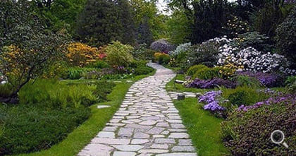 Gartenanlage mit geschwungen gepflasterten Polygonalplatten.