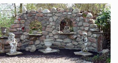 Garden place paved and natural stone wall with statues and Buddha.